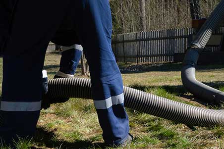 A person in blue pants and white shirt holding pipe