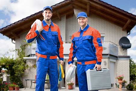 Two men in blue and orange work clothes.