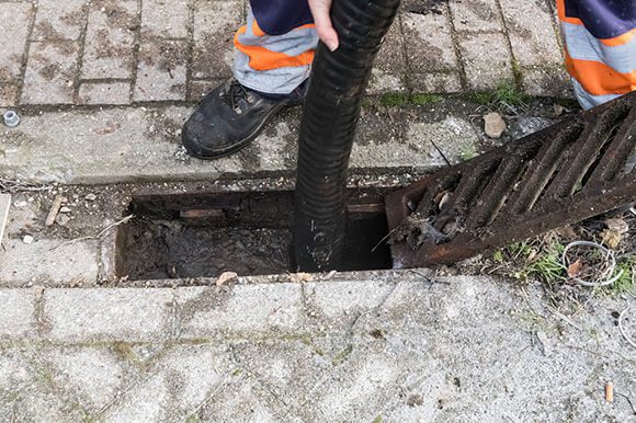 A person is standing on the ground near an open hole.