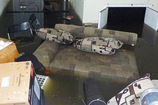 A couch with two pillows on it in the middle of a room.