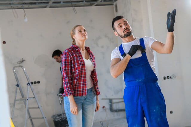 A man and woman are standing in front of another man.