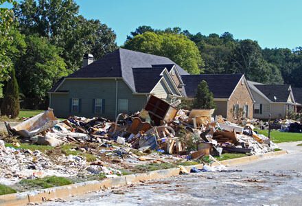 A pile of rubble in front of houses.