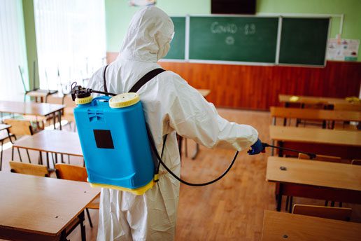 A person in white suit holding a blue backpack.