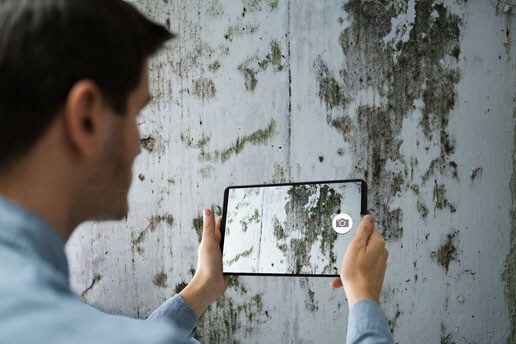 A man holding up an ipad to take a picture.