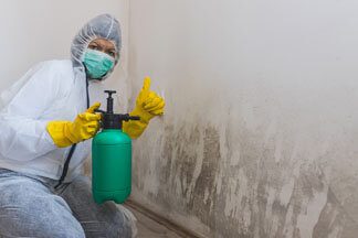 A person in white gloves holding a green bottle.