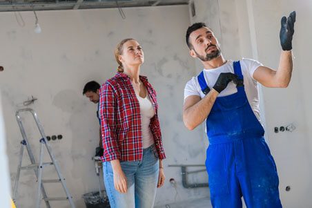 A man and woman looking at something in the room