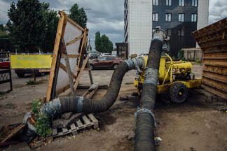 A yellow and black truck with pipes on the ground