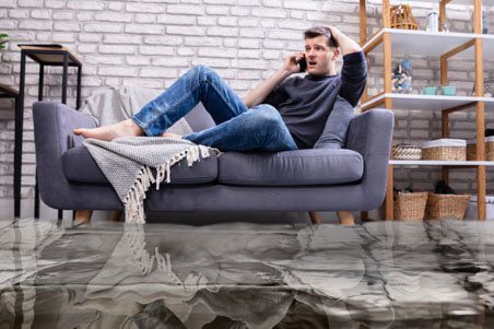 A man sitting on top of a couch talking on the phone.